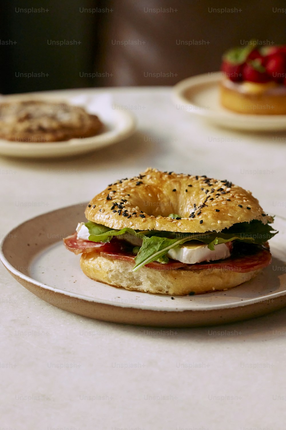 a bagel sandwich sitting on top of a white plate