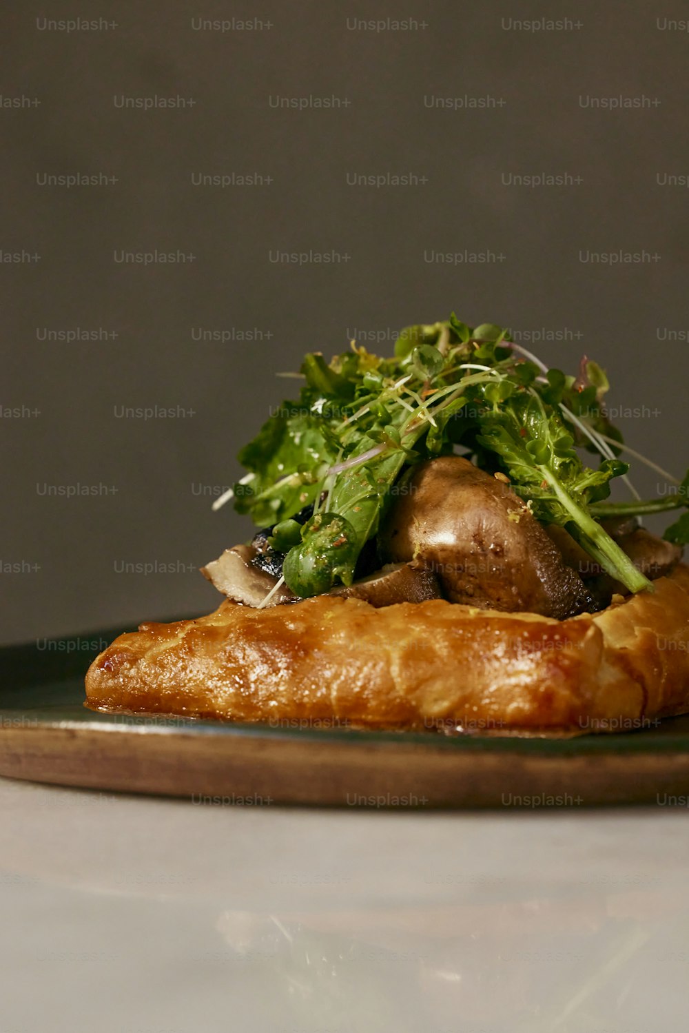 a piece of bread topped with greens and mushrooms
