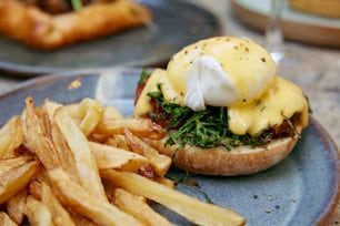 a blue plate topped with a sandwich and fries