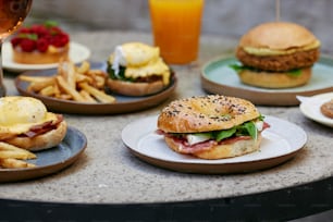 a table topped with plates of sandwiches and fries