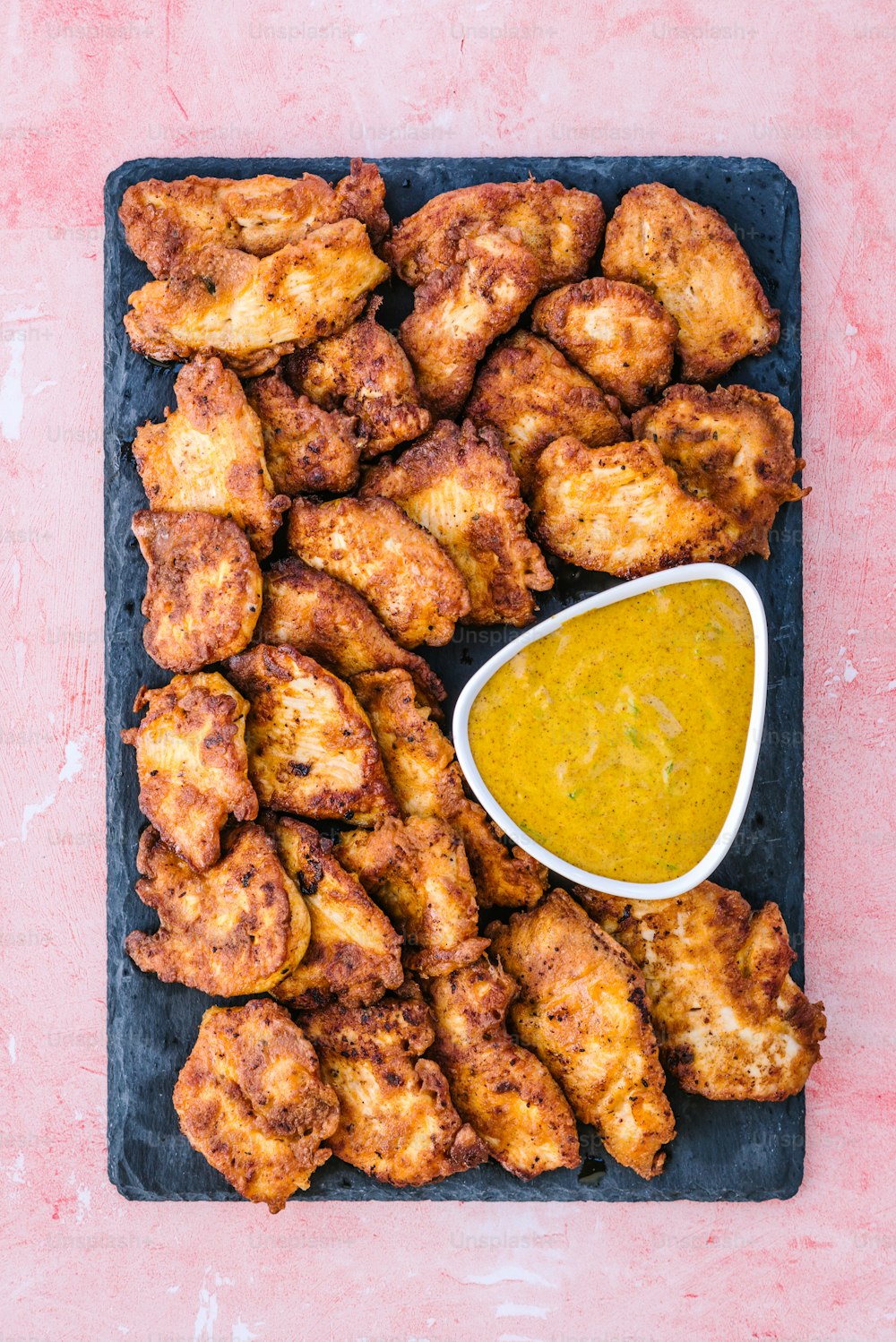 a plate of chicken wings with a dipping sauce