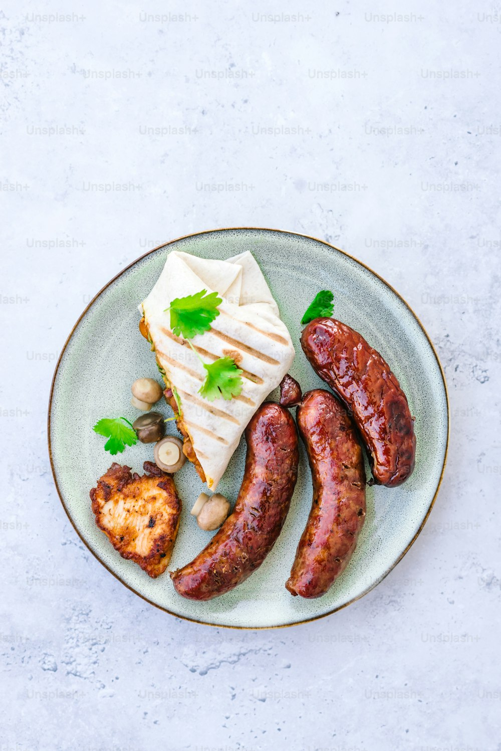 a plate with sausages, bread, and other foods on it