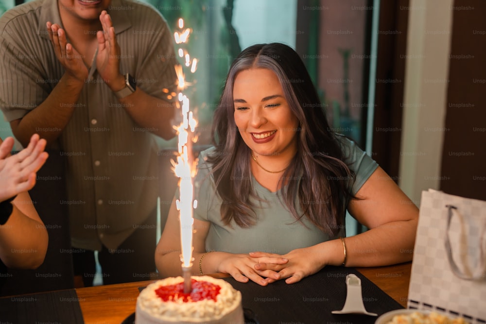 a woman sitting at a table in front of a cake