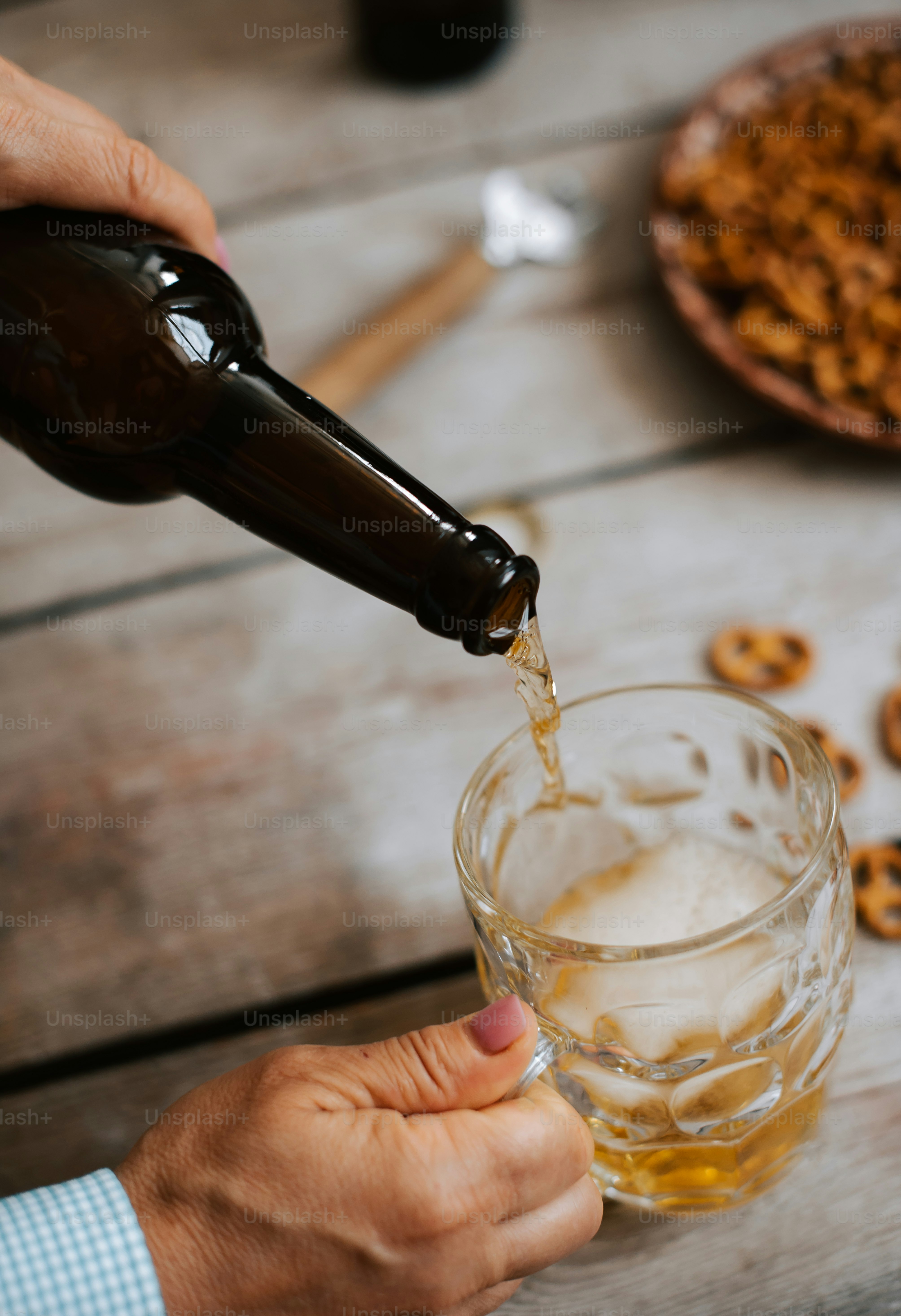 uma pessoa derramando cerveja em um copo