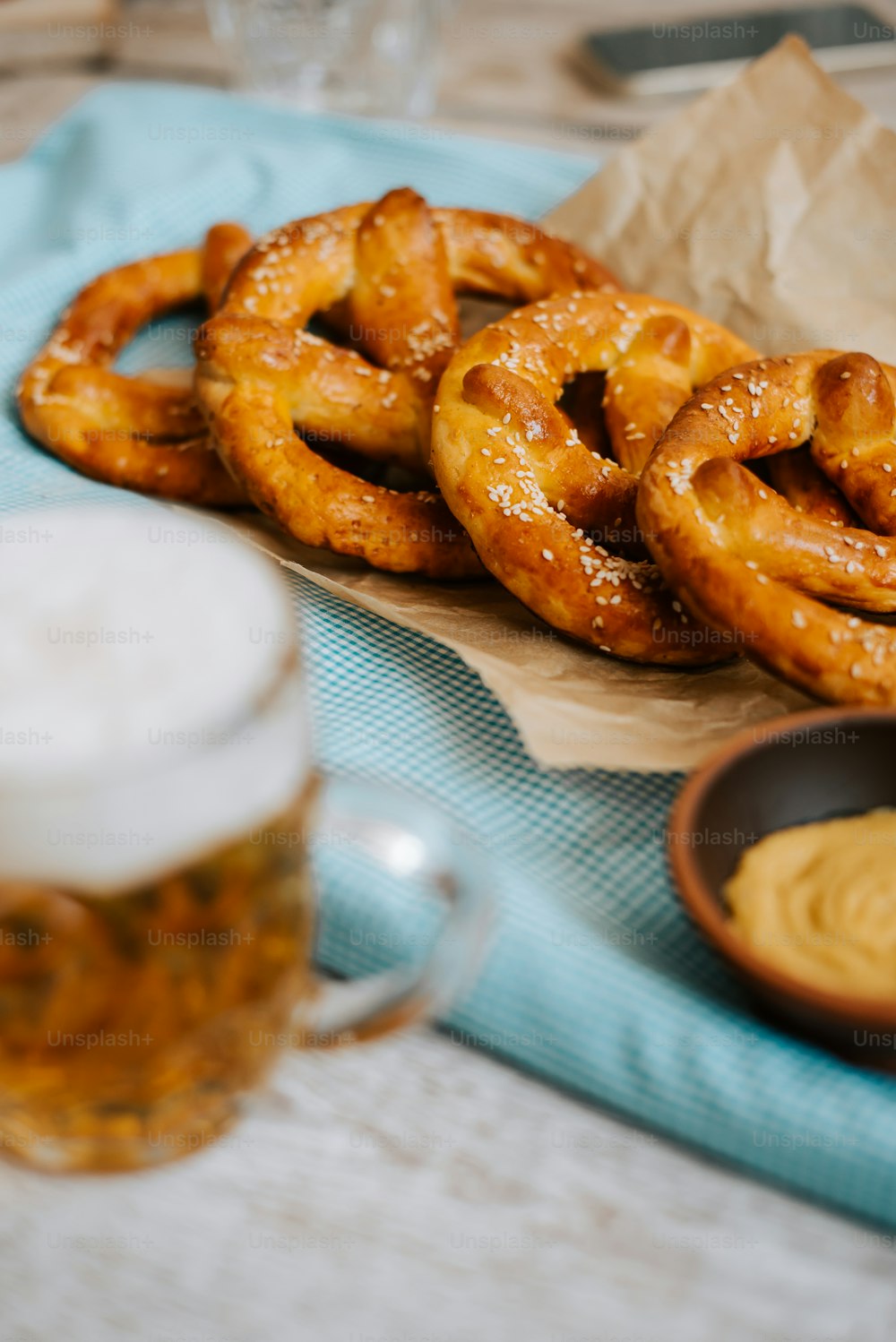 a table topped with pretzels next to a cup of beer