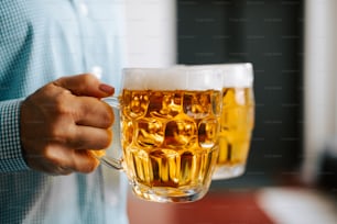 a man is holding a mug of beer