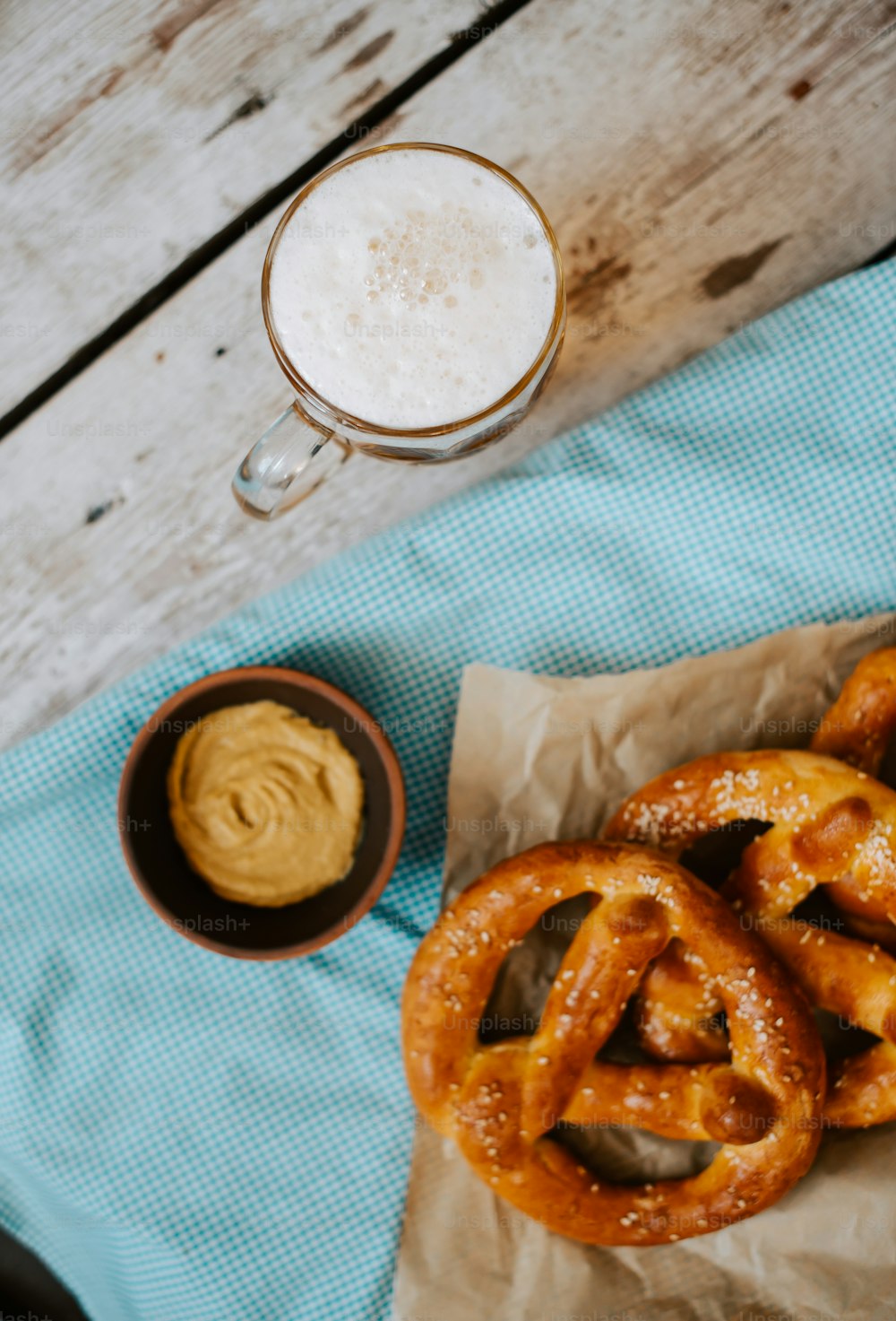 some pretzels and a cup of beer on a table
