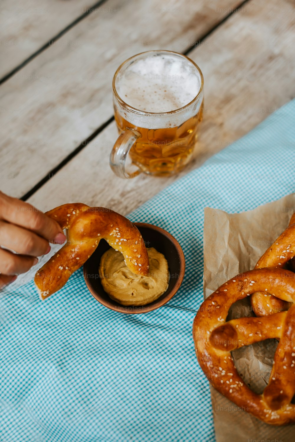 a person holding a pretzel over a bowl of pretzels