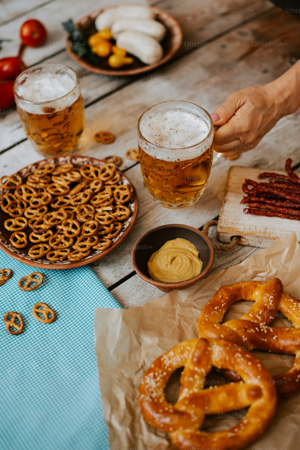 a table topped with pretzels, pretzels and beer