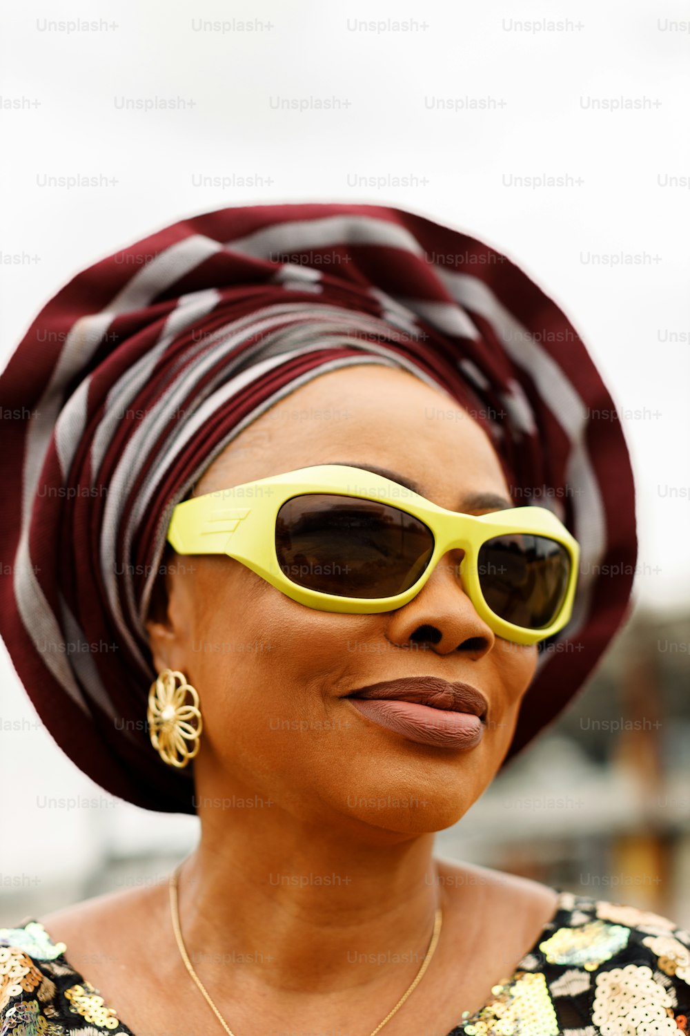a woman wearing yellow sunglasses and a turban