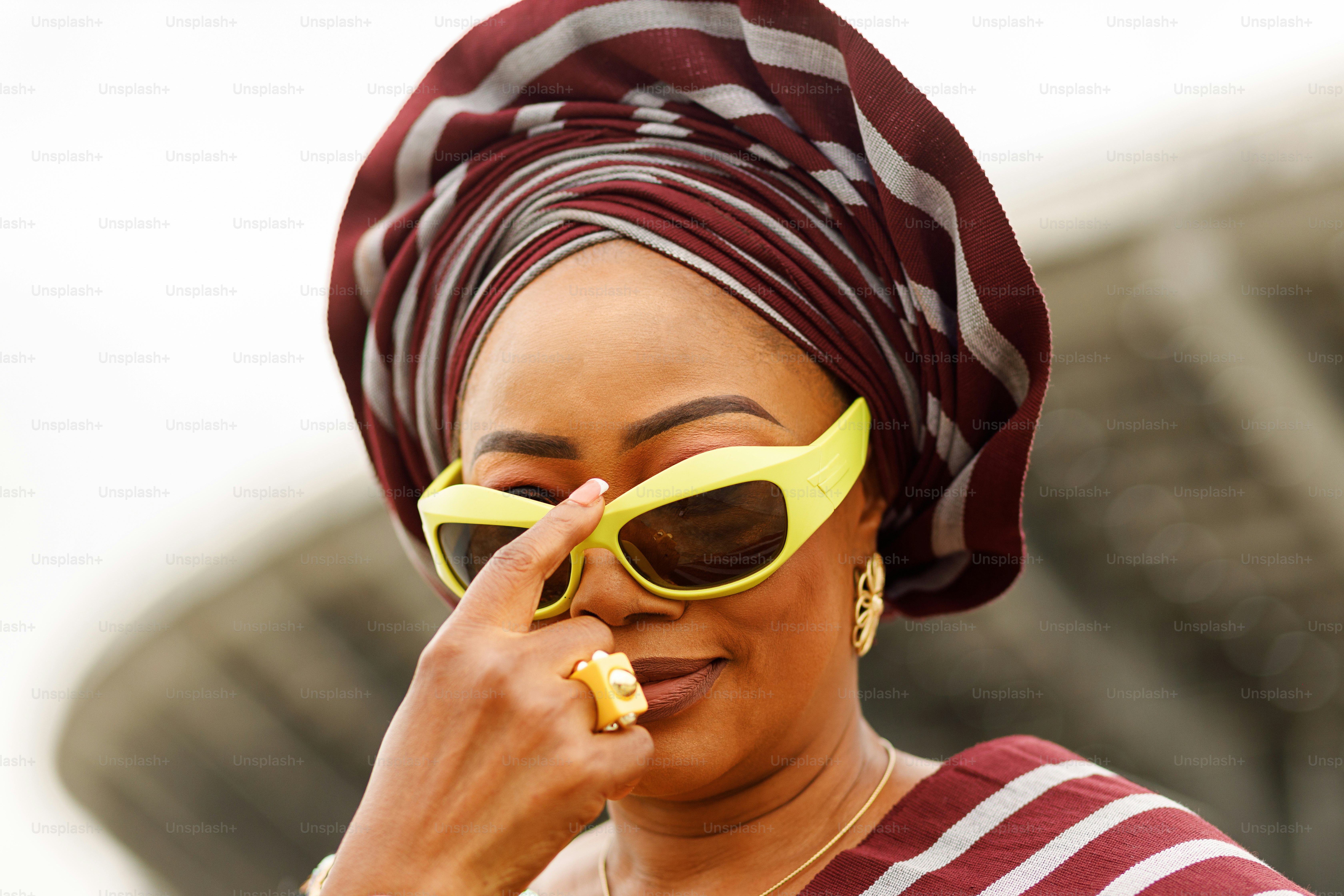 a woman wearing a red and white striped shirt and yellow sunglasses