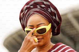 a woman wearing a red and white striped shirt and yellow sunglasses