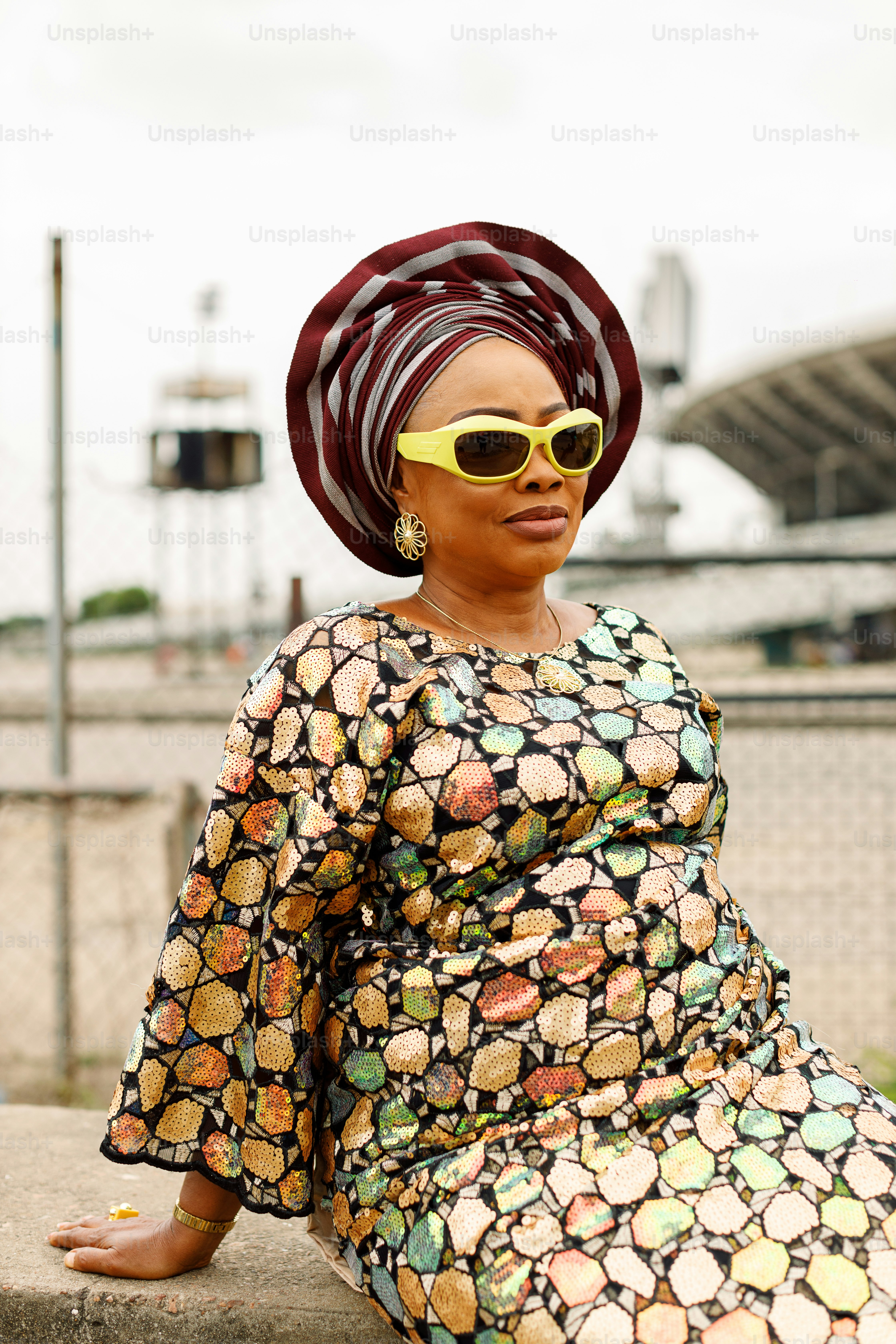 a woman sitting on a ledge wearing sunglasses