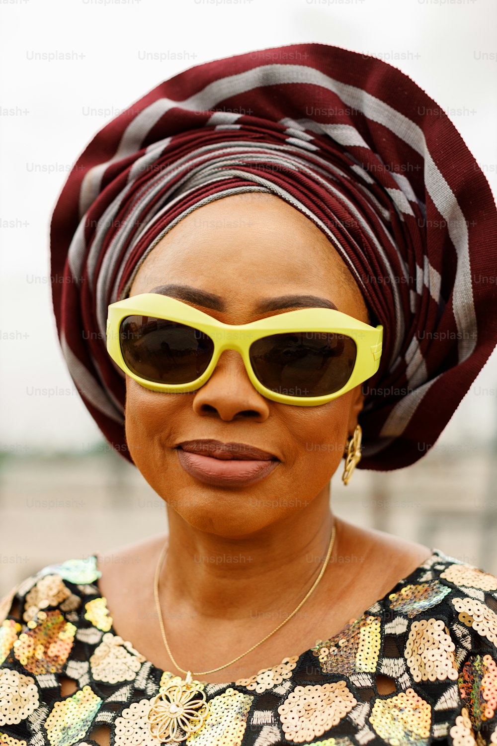 a woman wearing yellow sunglasses and a turban