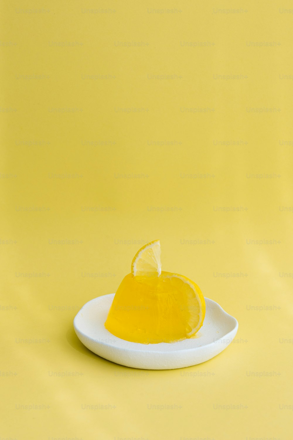eine Zitronenscheibe auf einem Teller auf gelbem Hintergrund