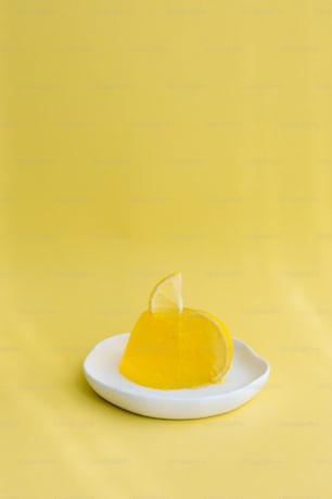 a slice of lemon on a plate on a yellow background