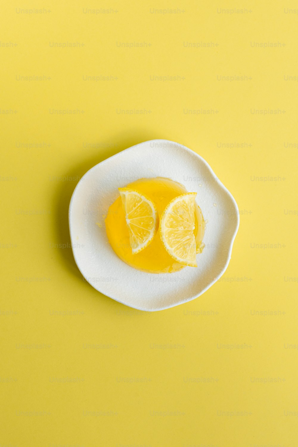 a white plate topped with sliced lemons on top of a yellow table