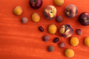 eine Gruppe von Früchten, die auf einer orangefarbenen Oberfläche sitzen