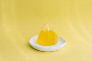 una fetta di limone seduta sopra un piatto bianco