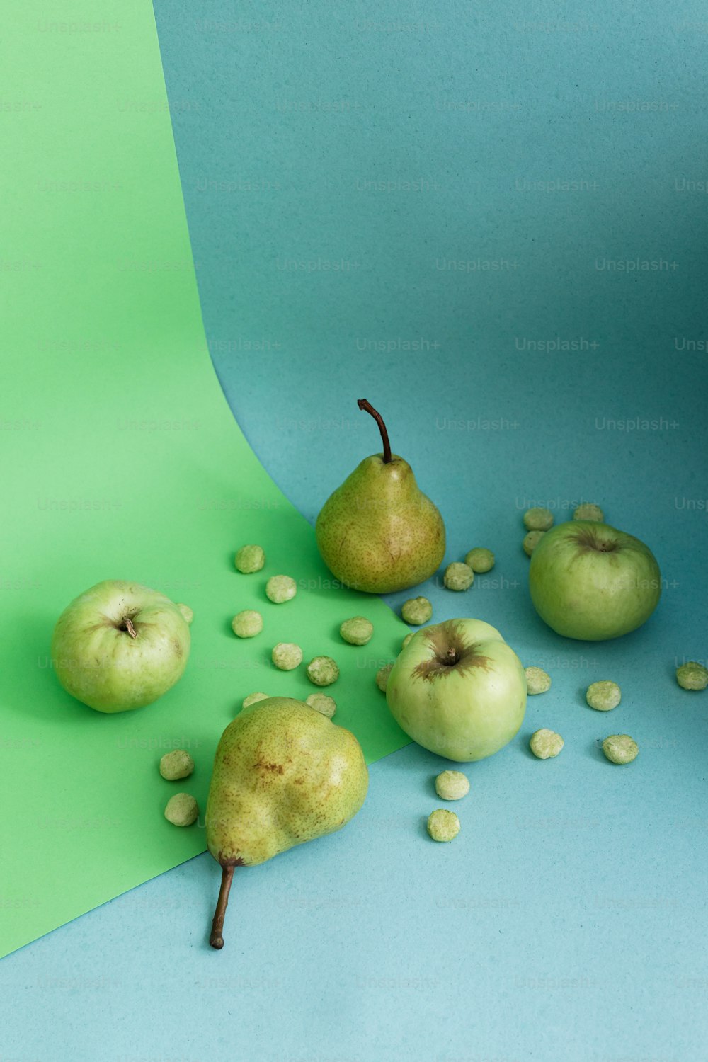 a group of green pears on a blue and green background