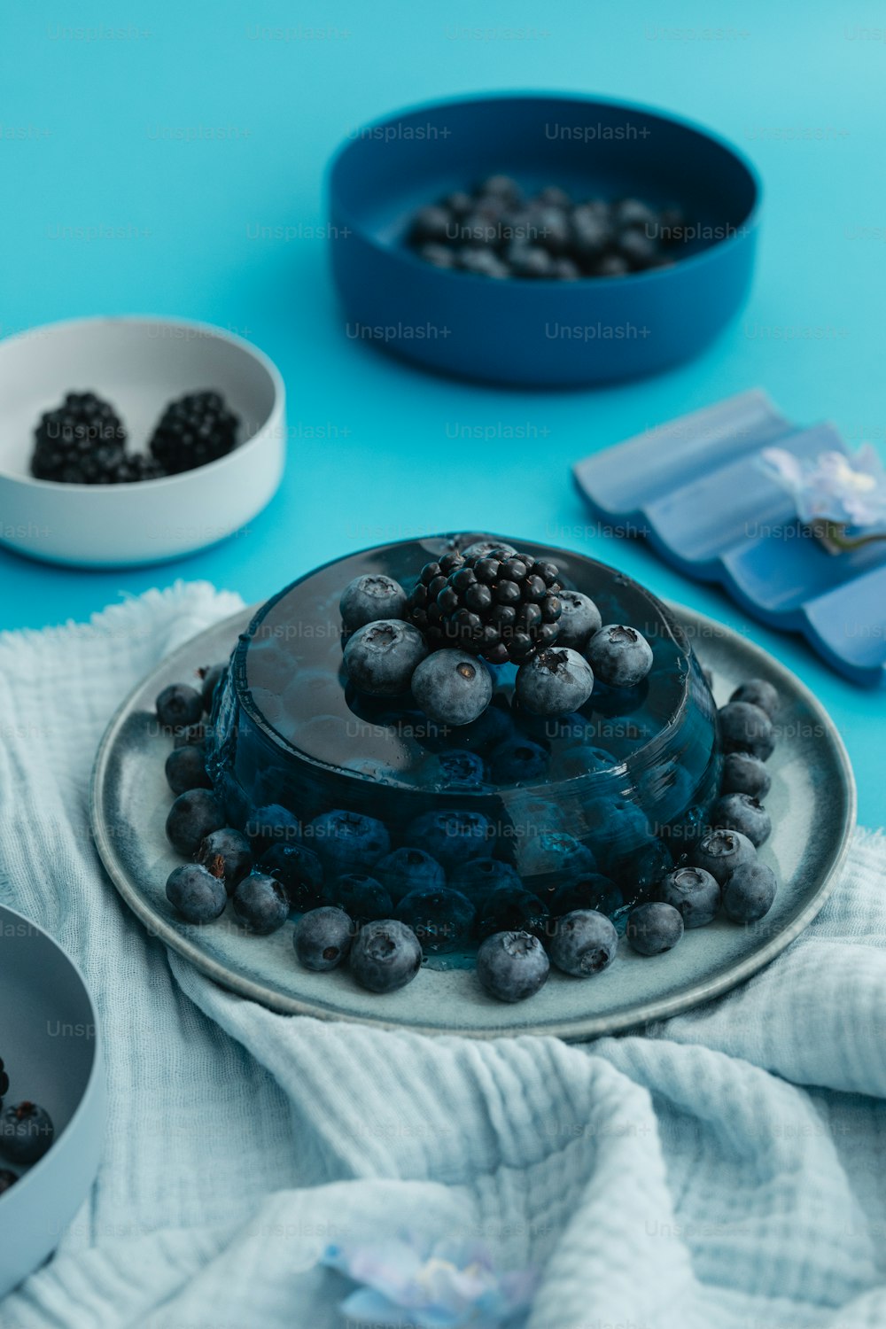 a cake with blueberries and blackberries on a plate