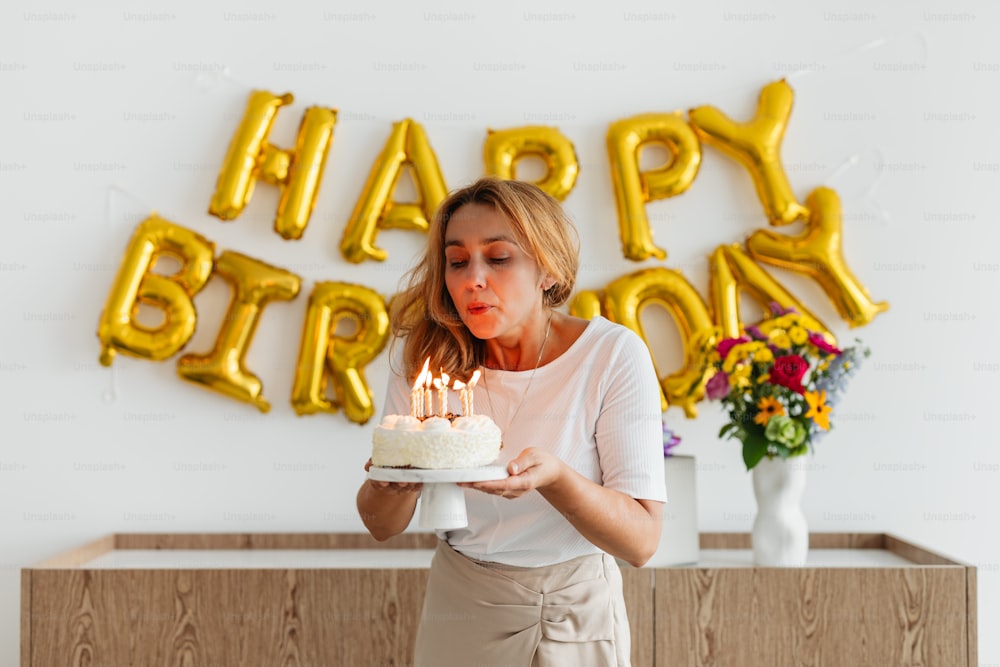 Una donna che spegne le candeline su una torta di compleanno