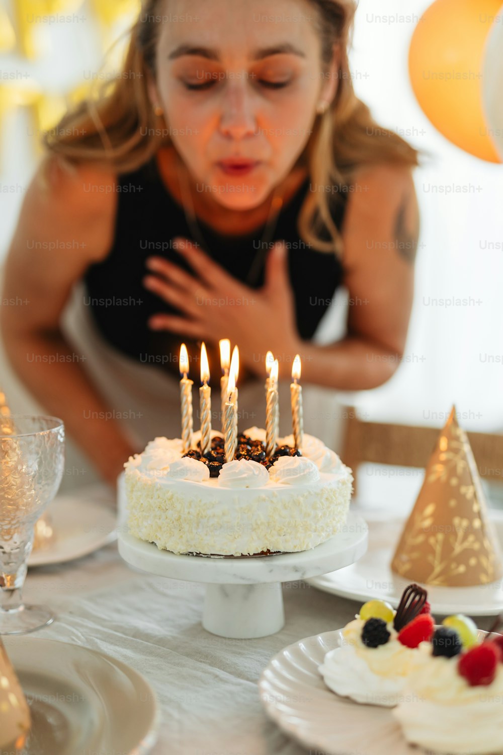 a woman blowing out candles on a cake