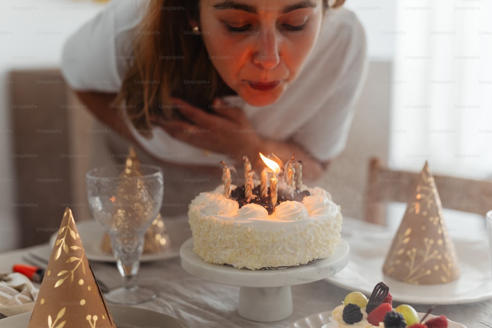 a woman blowing out candles on a cake