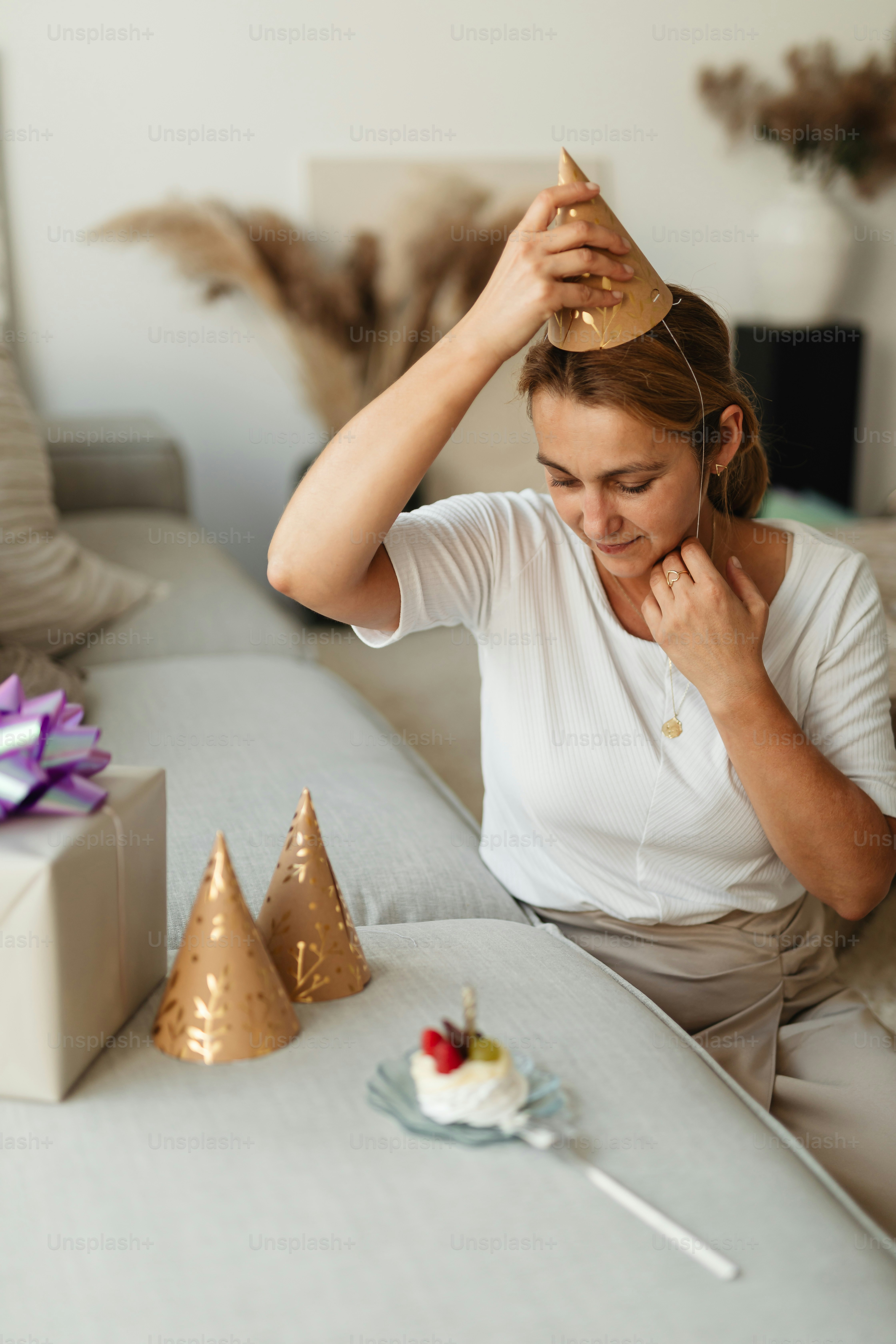 a woman sitting on a couch with a hat on her head