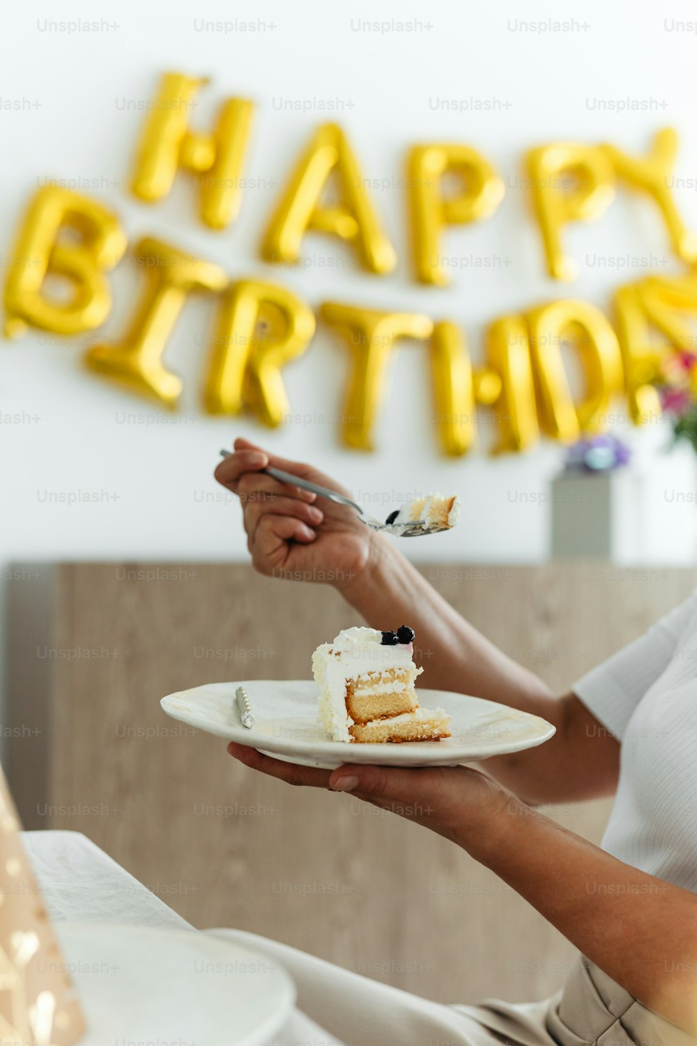 a woman holding a plate with a piece of cake on it