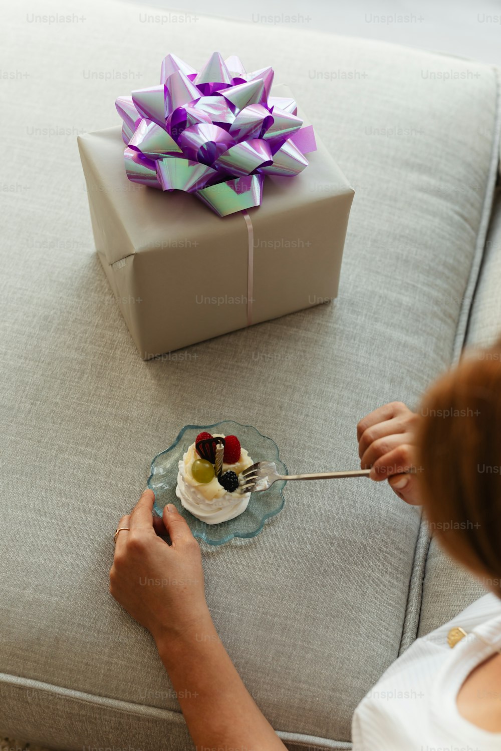 a woman is decorating a cake with purple ribbons