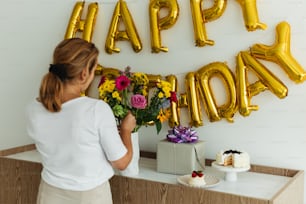a woman standing in front of a happy birthday sign