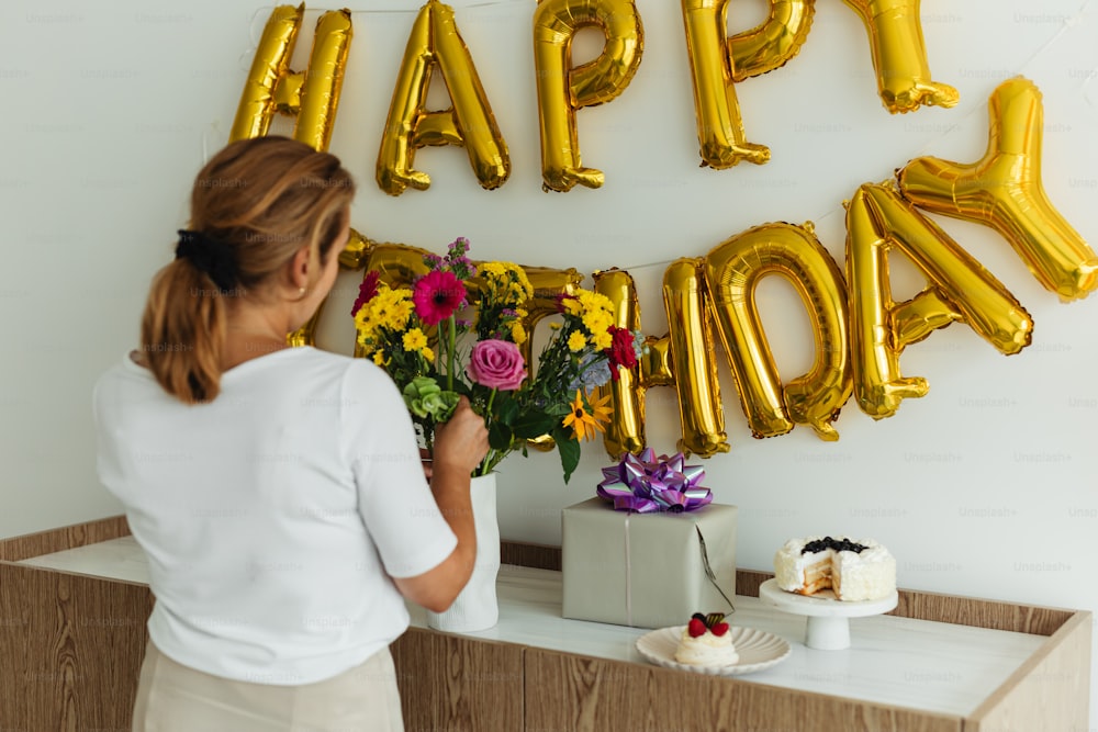 a woman standing in front of a happy birthday sign