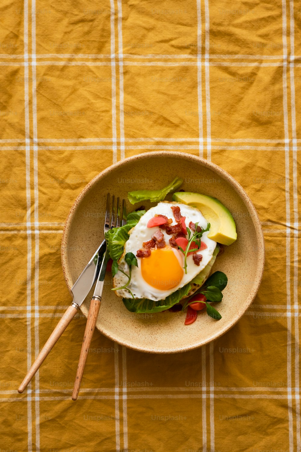 a plate of food with an egg and avocado