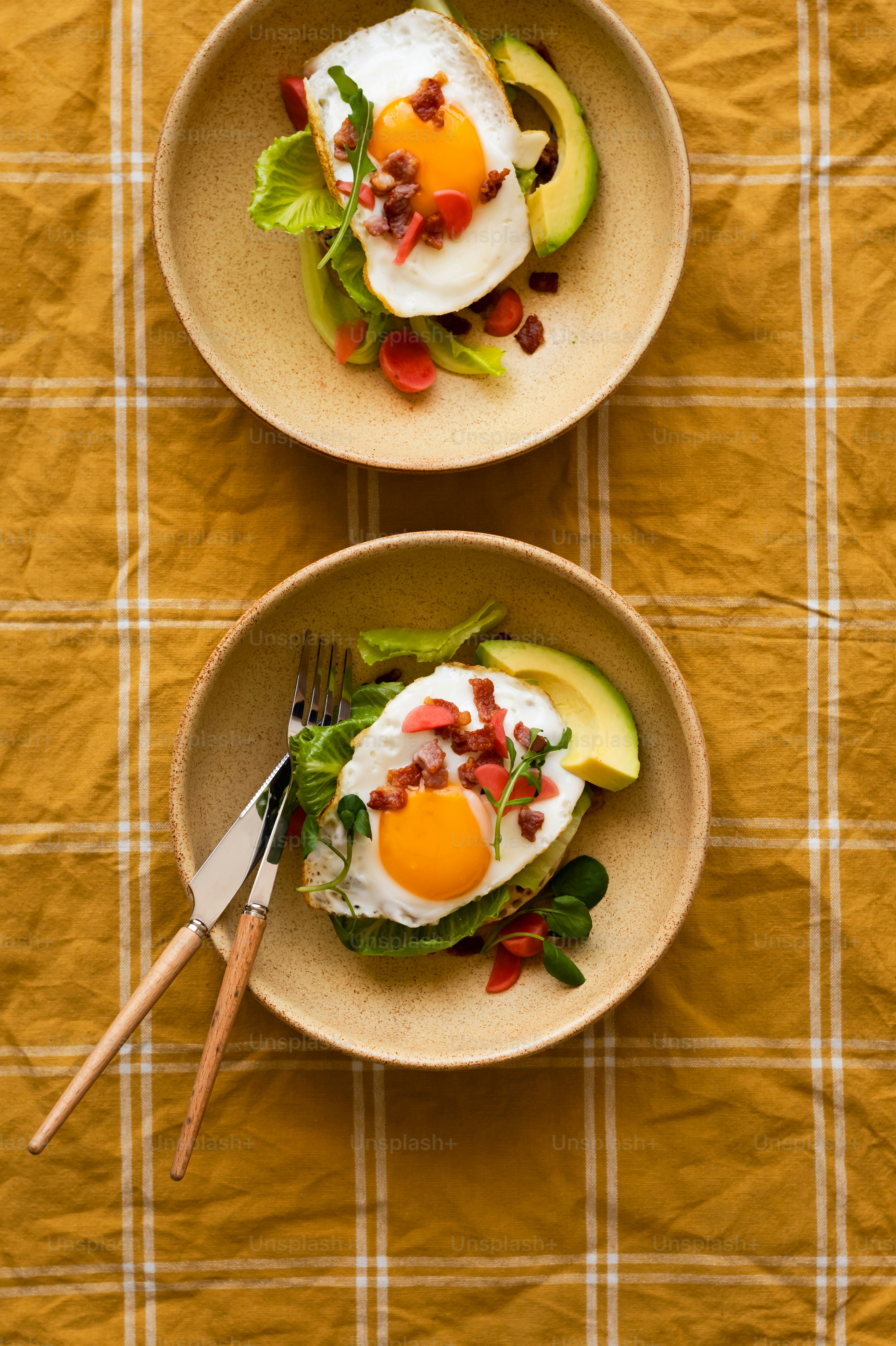 two bowls of food on a table with a fork