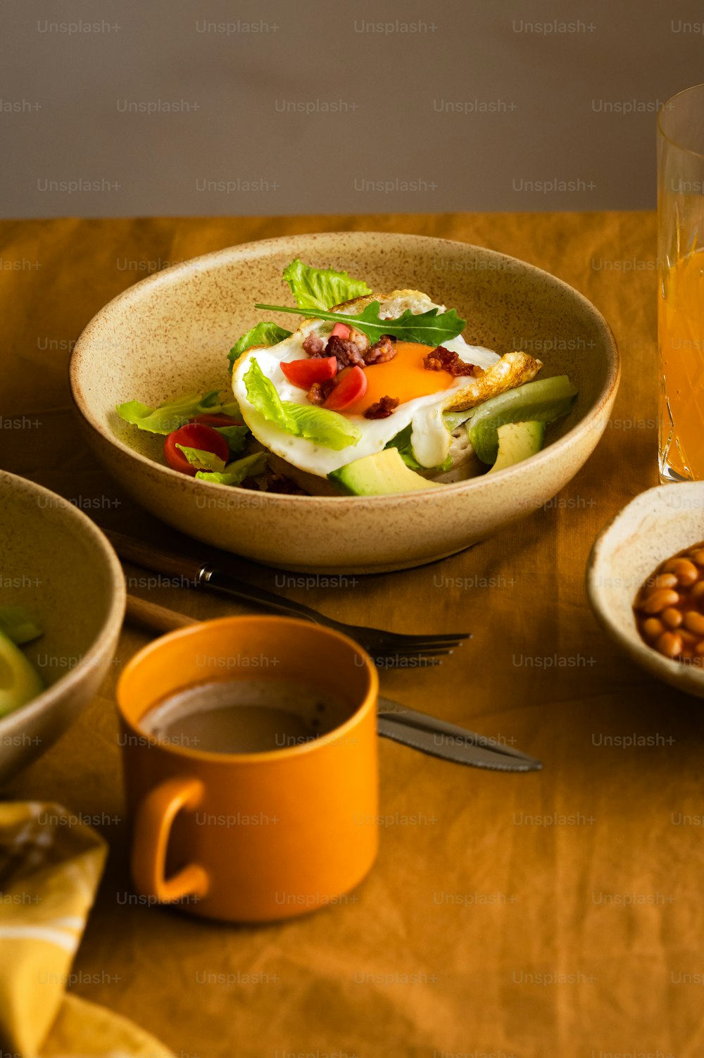 a wooden table topped with a bowl of food and a cup of coffee