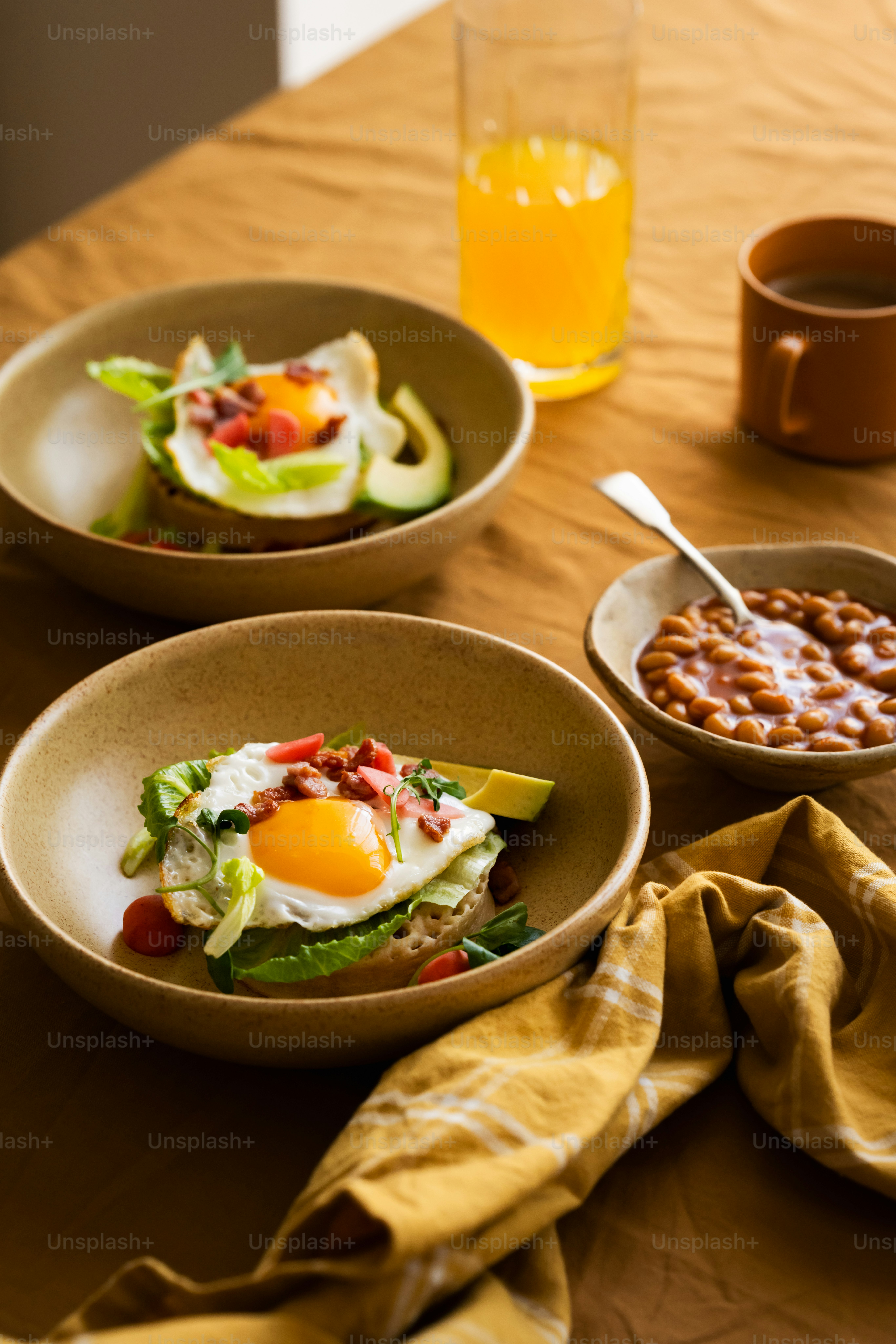a table topped with bowls of food and a bowl of beans