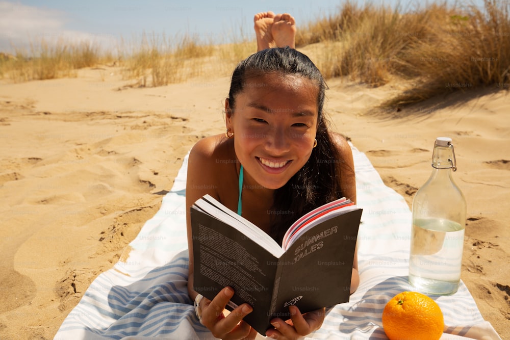 a girl reading a book on the beach