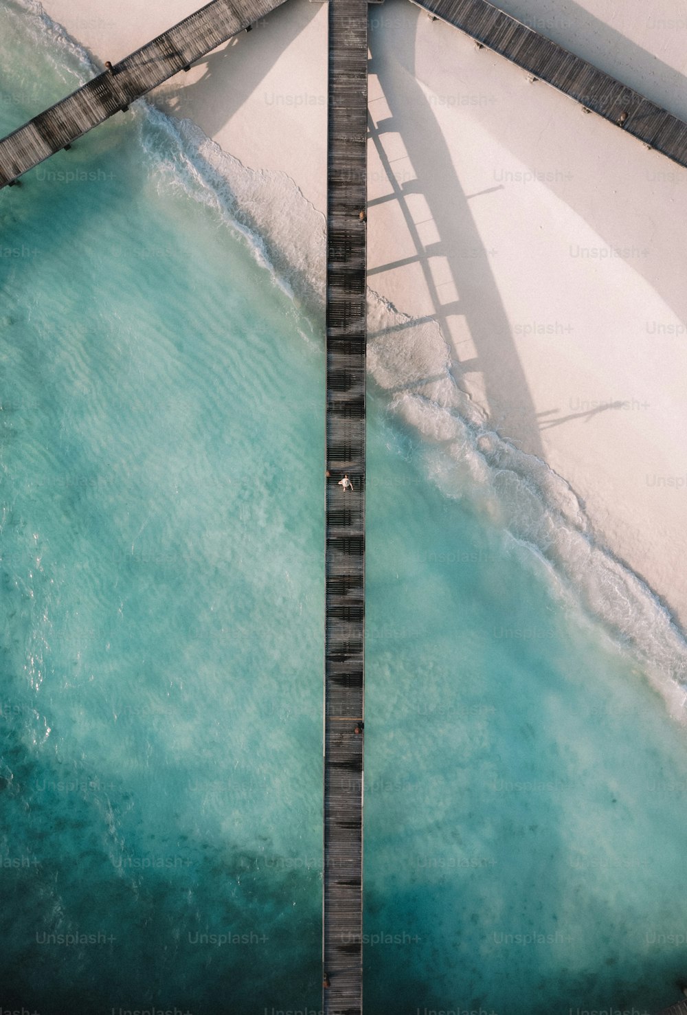 un pont au-dessus d’un plan d’eau à côté d’une plage