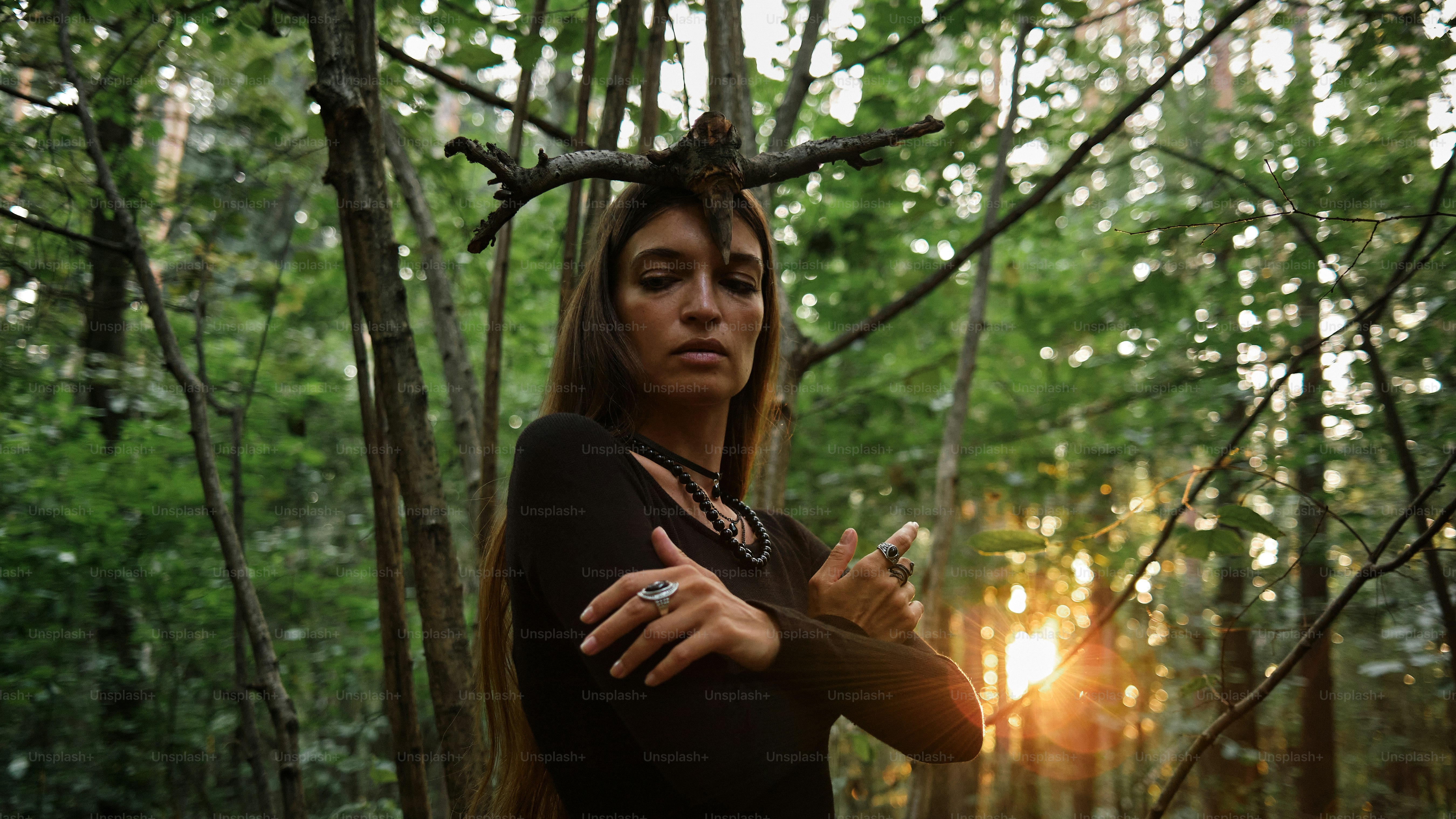 Una donna in piedi nel bosco con le braccia incrociate