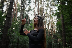 a woman in a forest with horns on her head