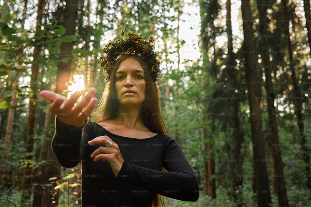 a woman wearing a wreath of flowers in a forest