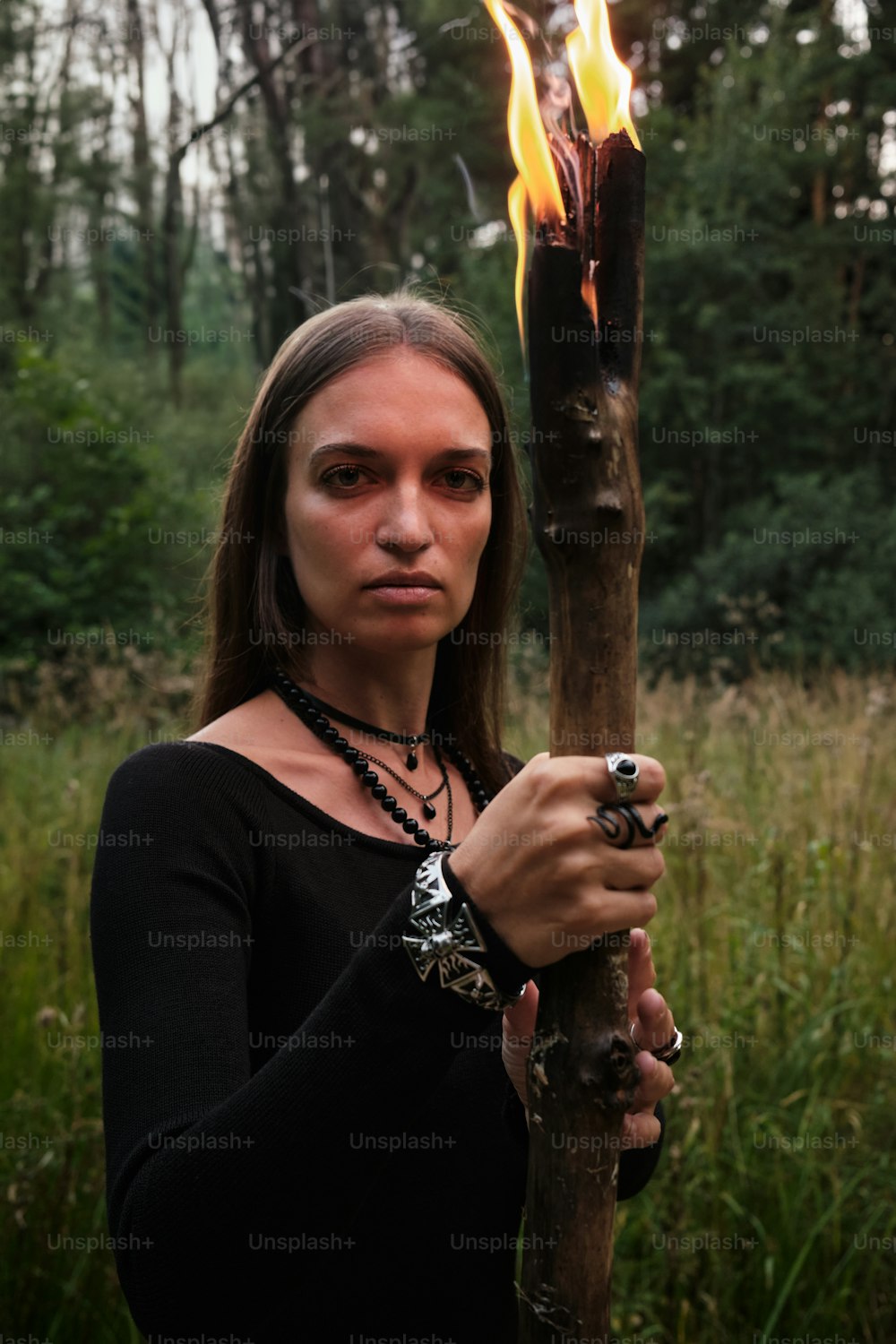 a woman holding a stick with a fire in it