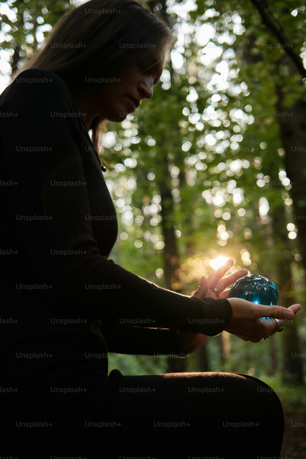 uma mulher segurando uma bola azul em suas mãos