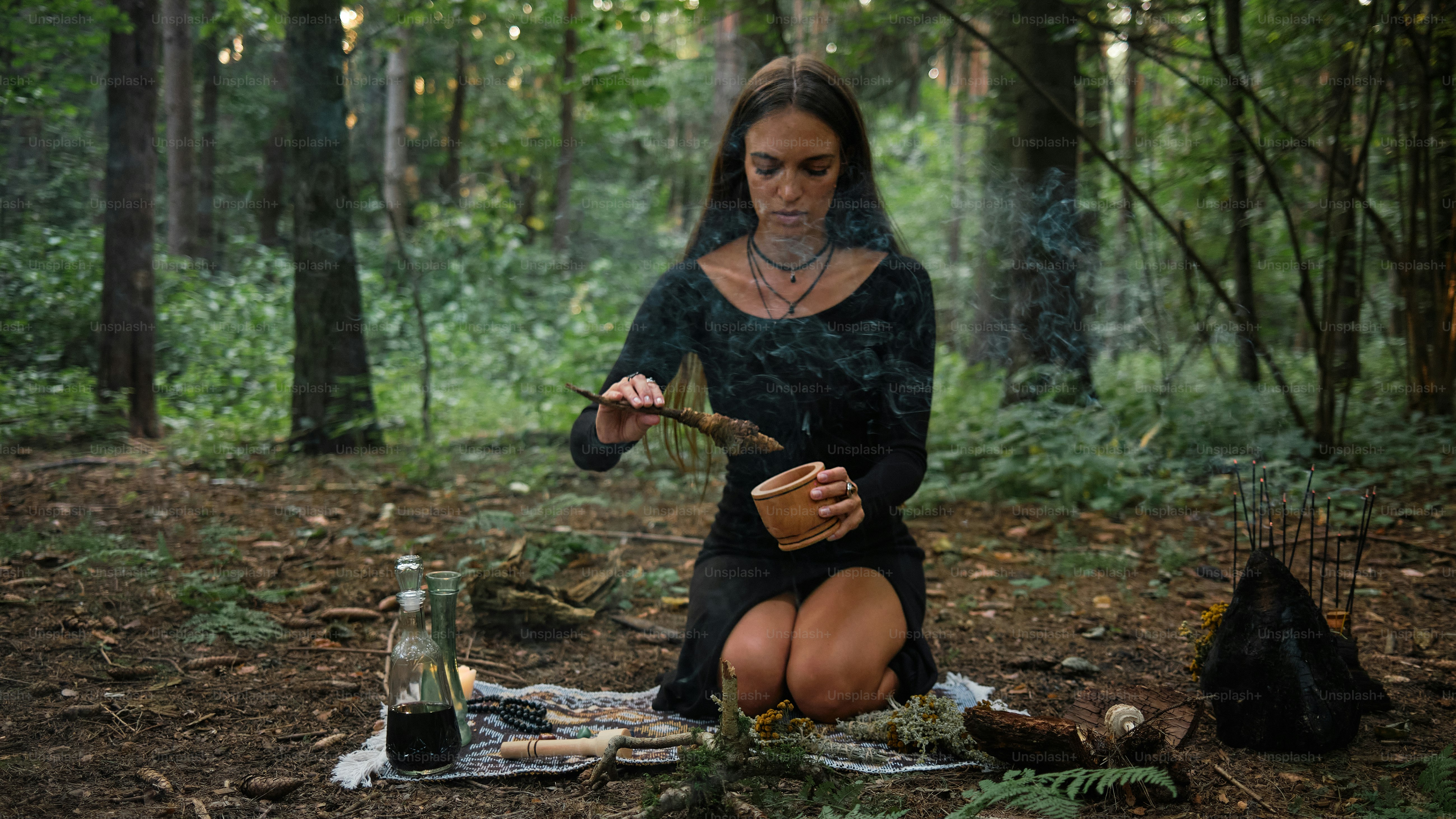eine frau, die auf dem boden im wald sitzt