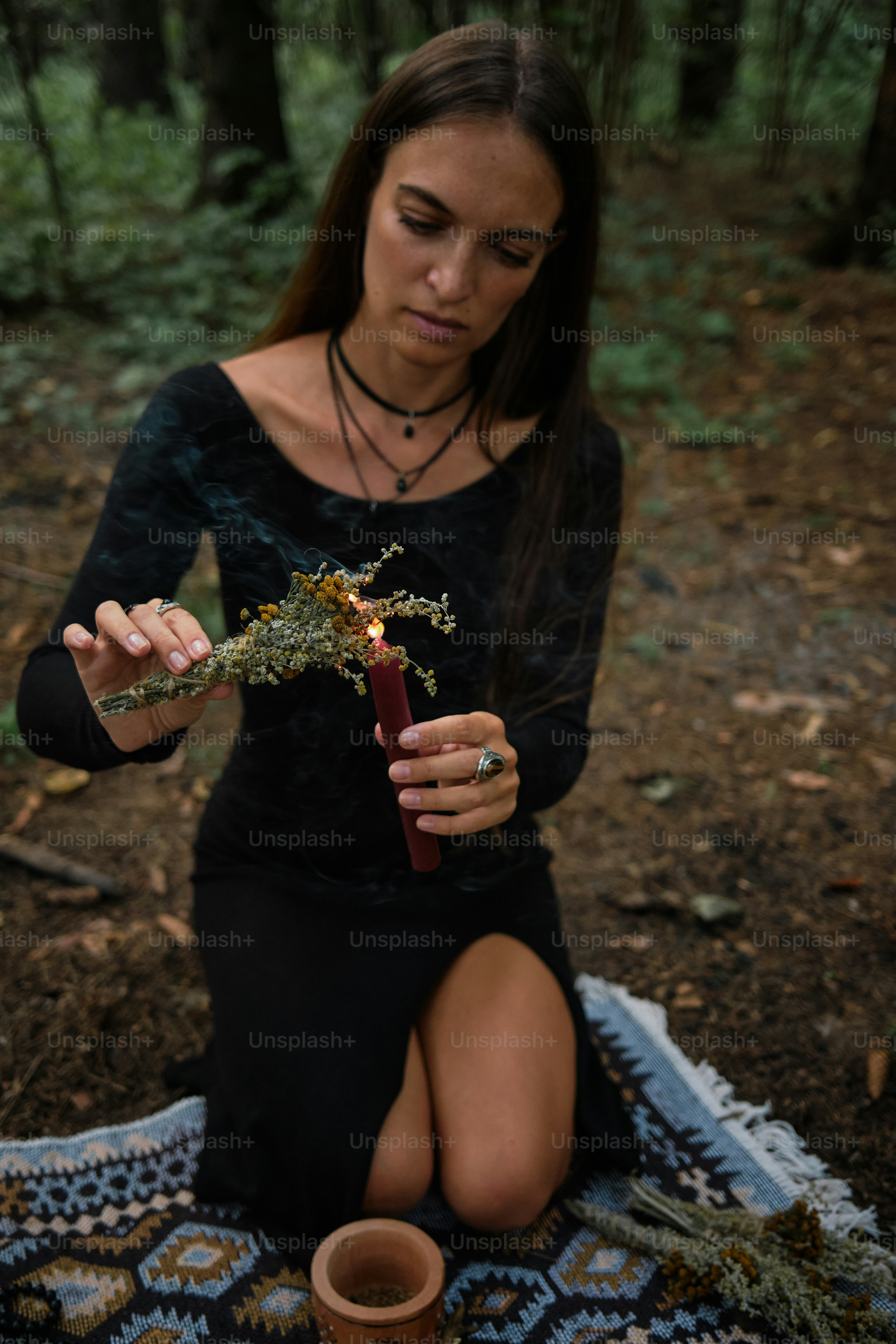 A woman sitting on a blanket holding a plant photo – Forest Image on ...