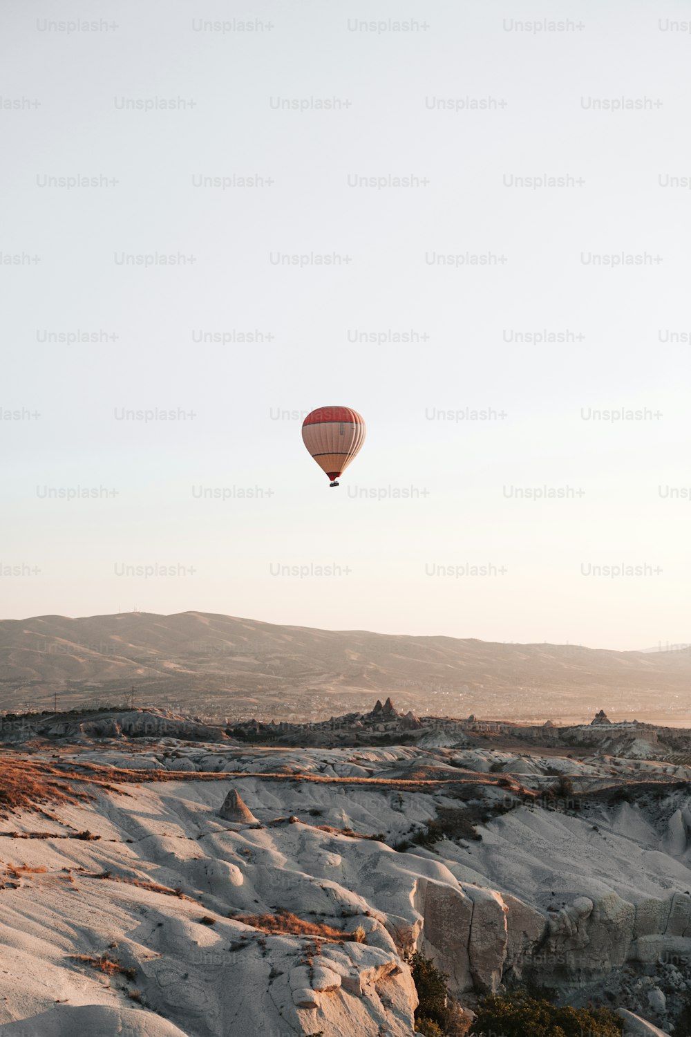 Ein Heißluftballon, der über eine felsige Landschaft fliegt