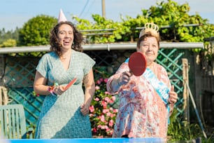 a couple of women standing next to each other holding ping pong paddles