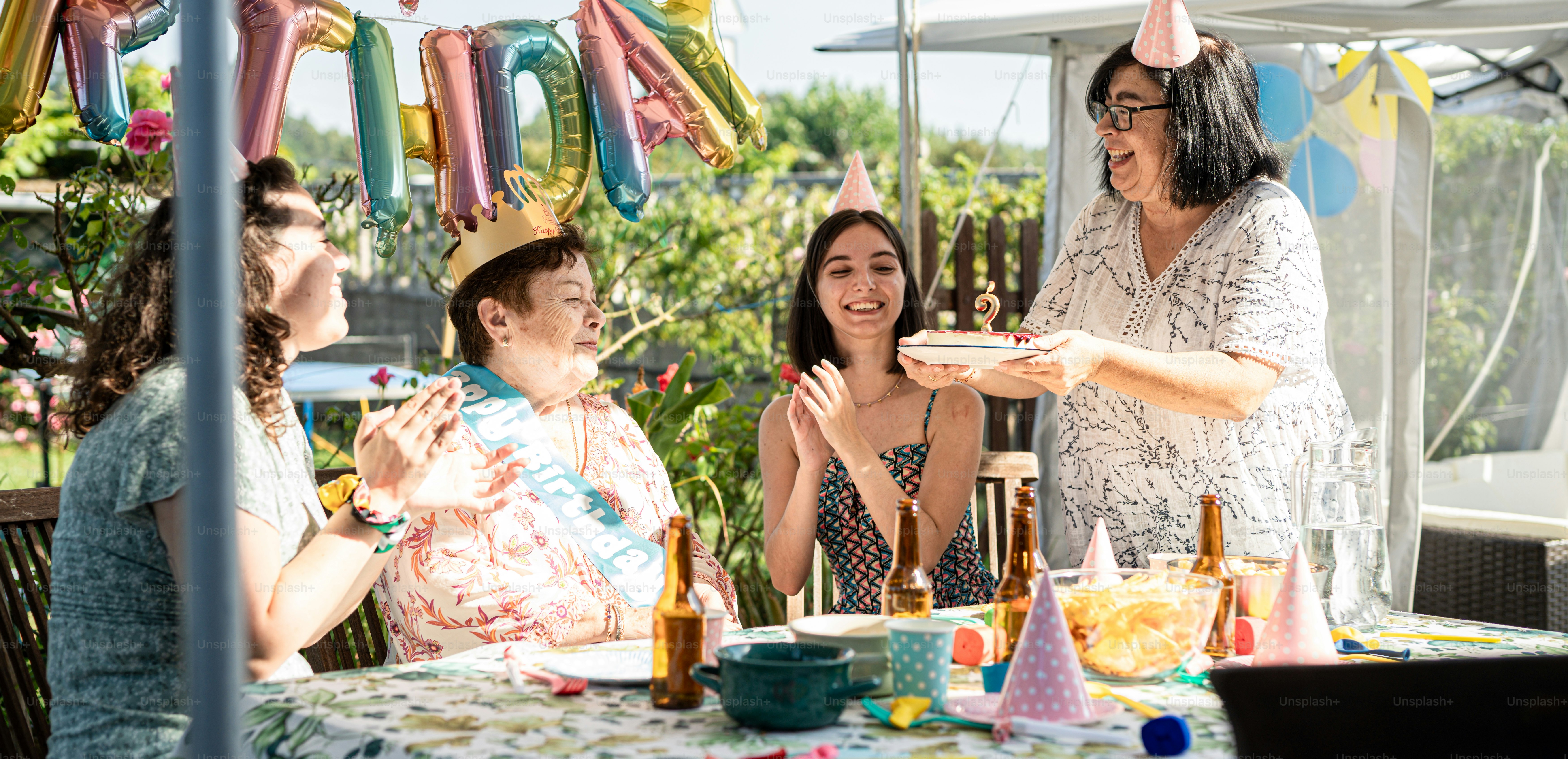 A group of people standing around a table with a cake photo ...