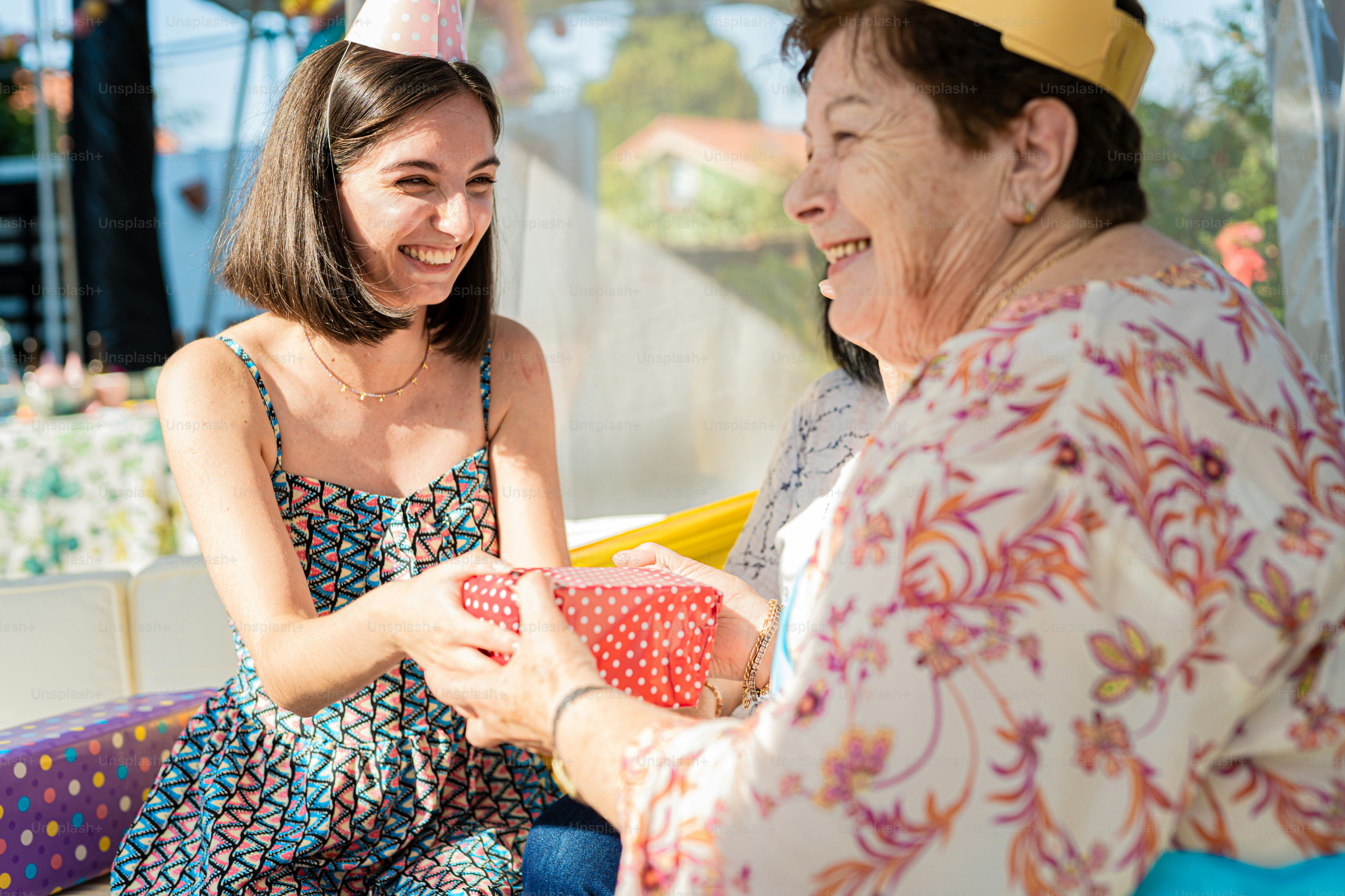 a woman sitting next to a woman in a party hat